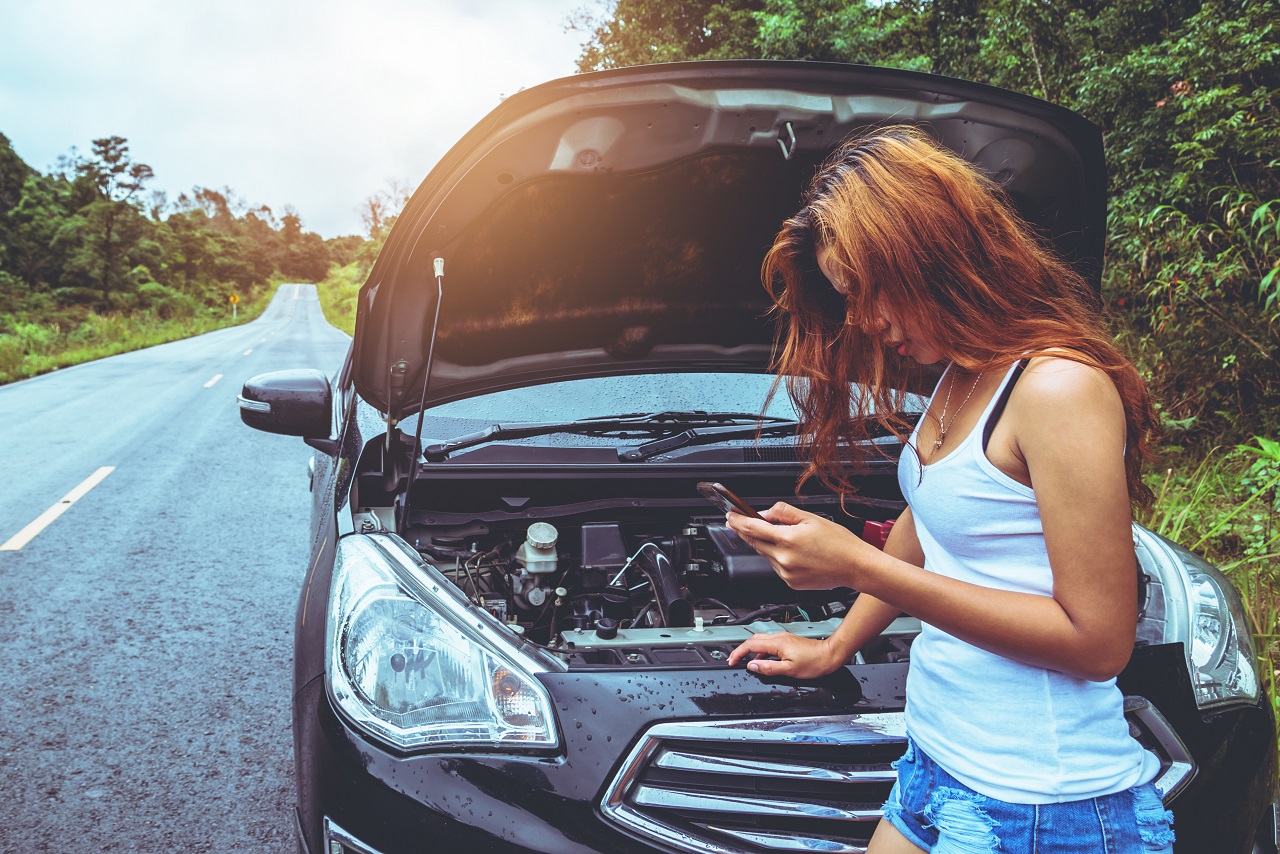 Woman On The Side Of A Rural Road Calling For Roadside Assistance On A Cell Phone