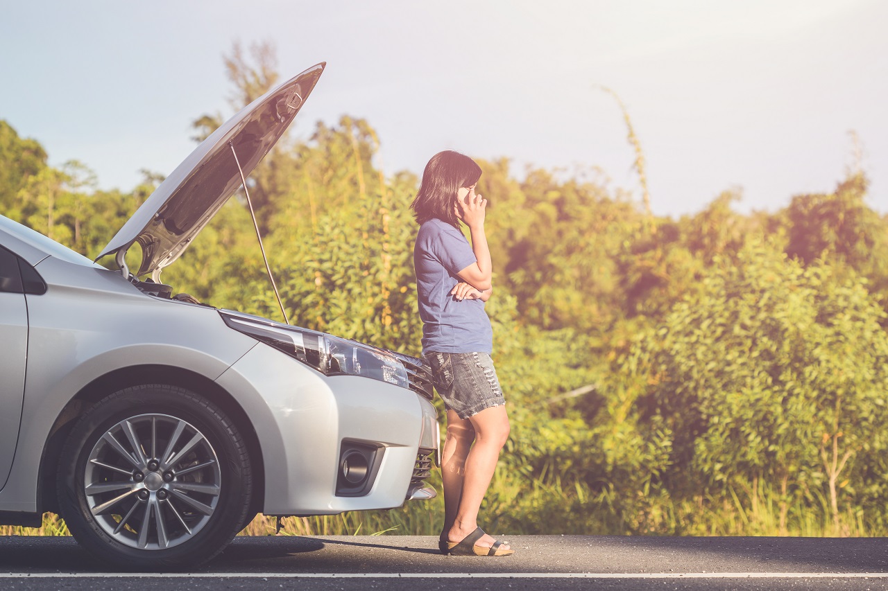 Lady Sitting On The Car Bumper Calling For a Towing Service