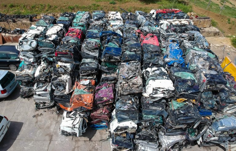 Cars in junkyard, pressed and packed for recycling.